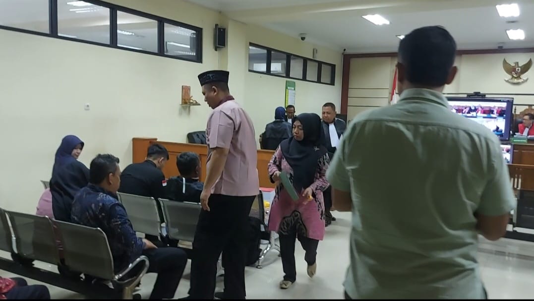 Terdakwa Heri Acmadi (berpeci) dan Sari Diah Ratna (Batik merah) usai menjalani sidang pleidoiatas perkara dugaan korupsi Trosobk di Pengadilan Tipikor Surabaya