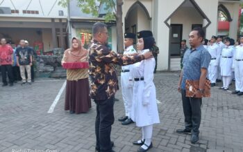 Camat Taman secara simbolis menyematkan pin tanda anggota Paskibraka telah resmi dikukuhkan