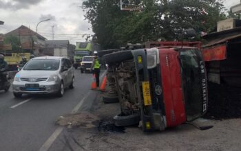 Baut ban belakang lepas, dump truk muat batu bara terguling menimpa bengkel sepeda motor