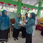 Ketua TP PKK Kecamatan Taman, Diah Arie Prabowo, A.Md.Kep, menyerahkan piala serta piagam kepada Ketua TP PKK Desa Pertapan Maduretno sebagai pemenang lomba administrasi PKK