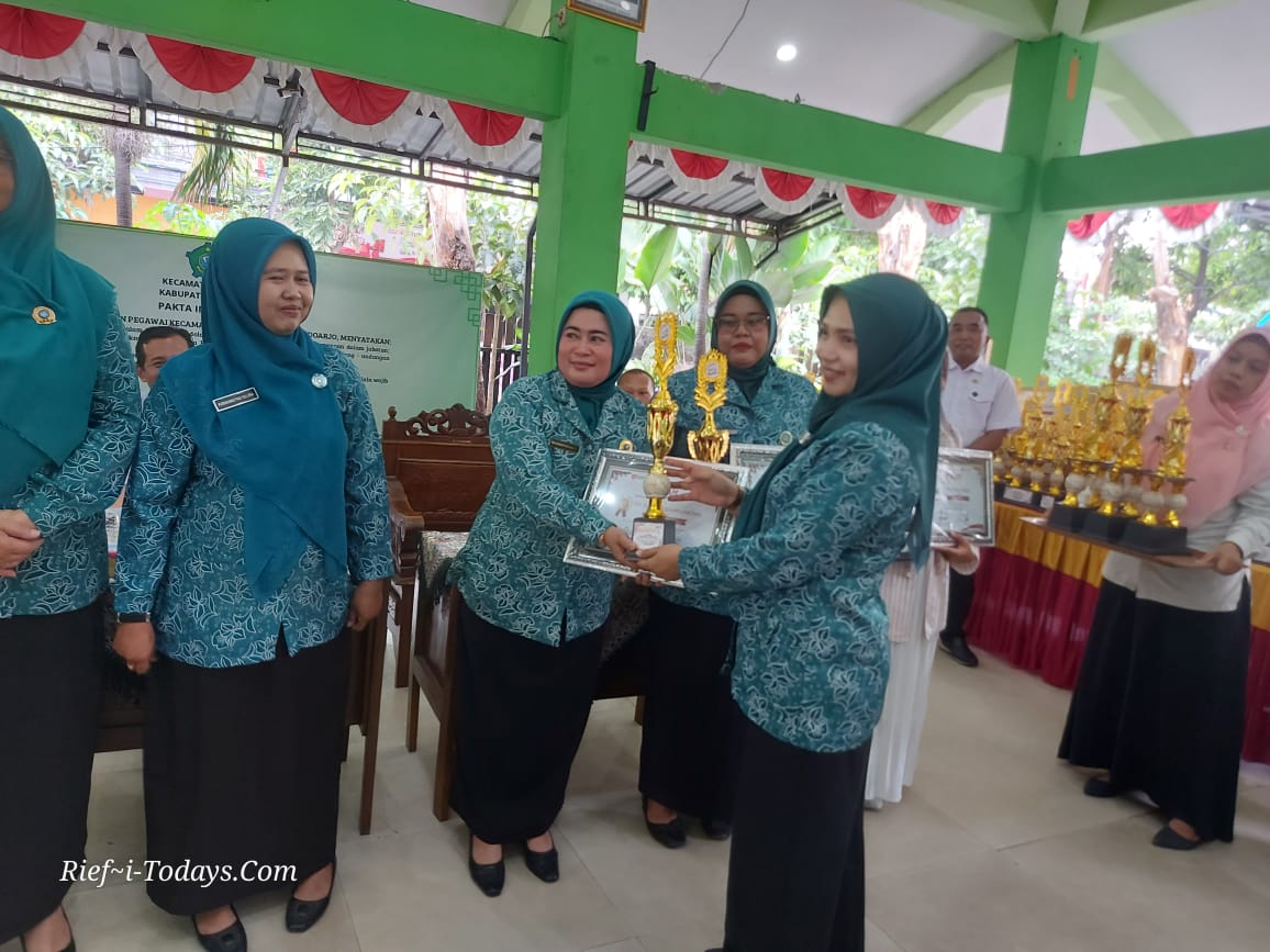 Ketua TP PKK Kecamatan Taman, Diah Arie Prabowo, A.Md.Kep, menyerahkan piala serta piagam kepada Ketua TP PKK Desa Pertapan Maduretno sebagai pemenang lomba administrasi PKK