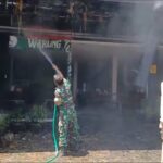 Danramil 0816/14 Taman, Kapten Arh. Mukhlis Harianto (Kiri) turun langsung membantu proses pemadaman api yang membakar "Warung Tombo Ati" yang berada dikawasan Stasiun KA Sepanjang
