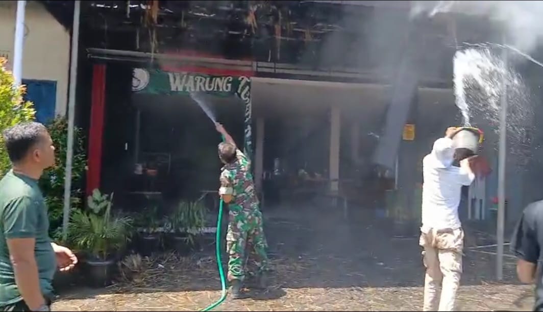 Danramil 0816/14 Taman, Kapten Arh. Mukhlis Harianto (Kiri) turun langsung membantu proses pemadaman api yang membakar "Warung Tombo Ati" yang berada dikawasan Stasiun KA Sepanjang