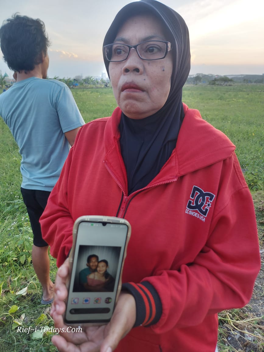 Jamilah Ibunda Arista, tengah memegang handphone dengan wallpaper foto korban.