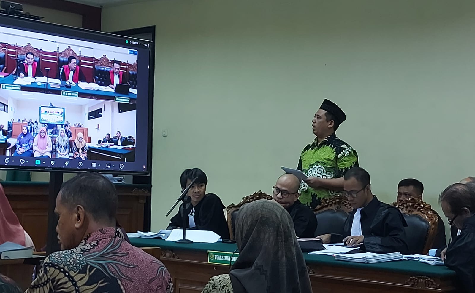 Kades Trosbo, Heri Achmadi, SH (batik hijau) saat menjalani persidangan di Pengadilan Tipikor PN Surabaya.