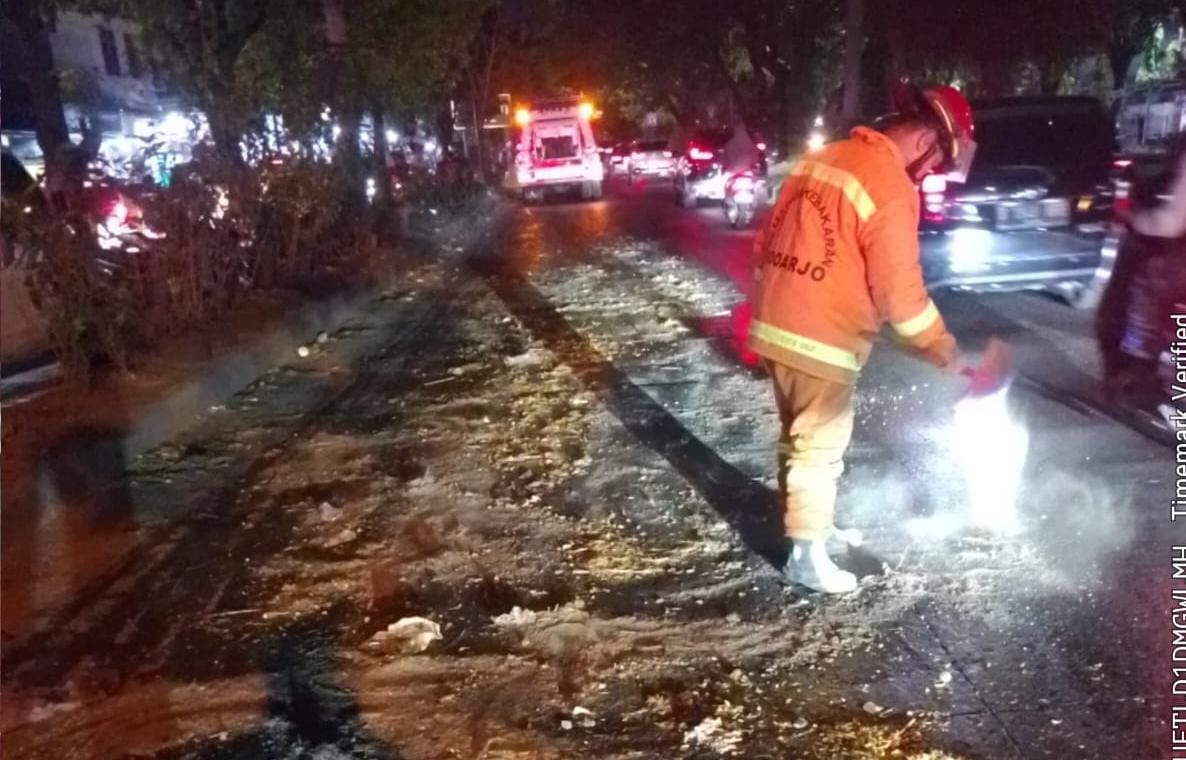 Petugas Damkar membersihkan tumpahan minyak dari jerigen yang terjatuh dan pecah dijalan Raya Juanda