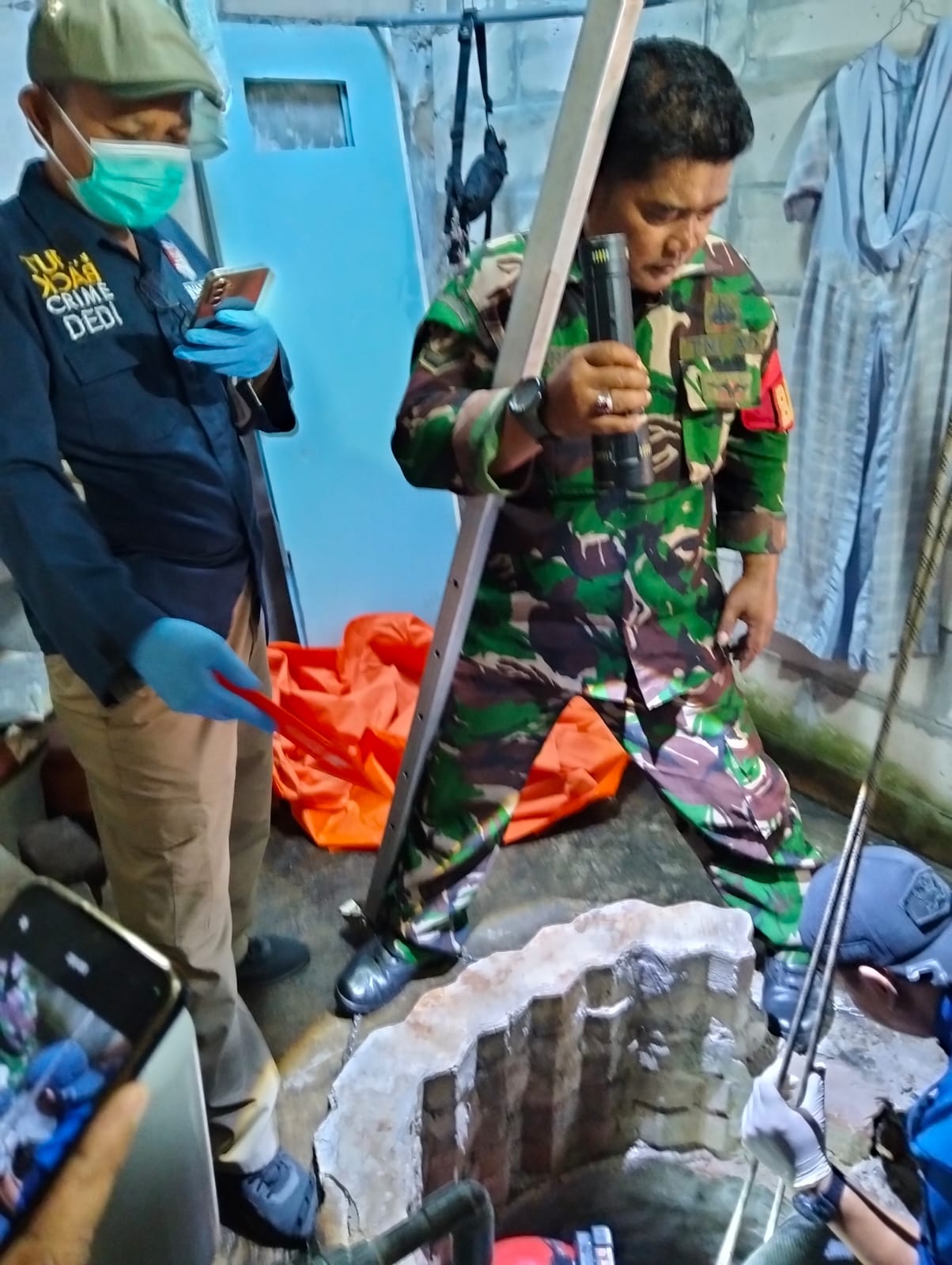 Petugas gabungan saat mengevakuasi korban dari dalam sumur