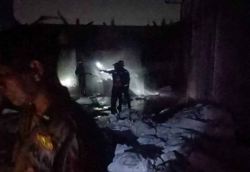 Petugas Damkar tengah berupaya memadamkan api yang melahap bangunan.